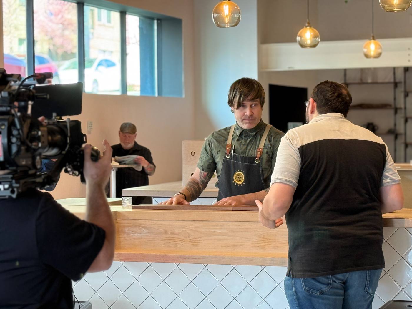The barista stares down Brad across the counter
