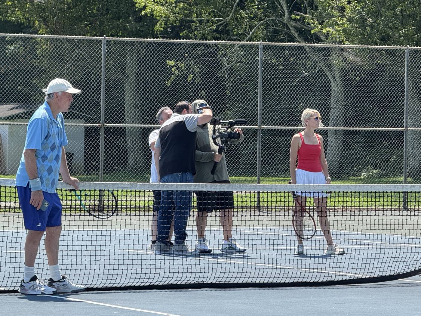 Crew frames a shot on a tennis court